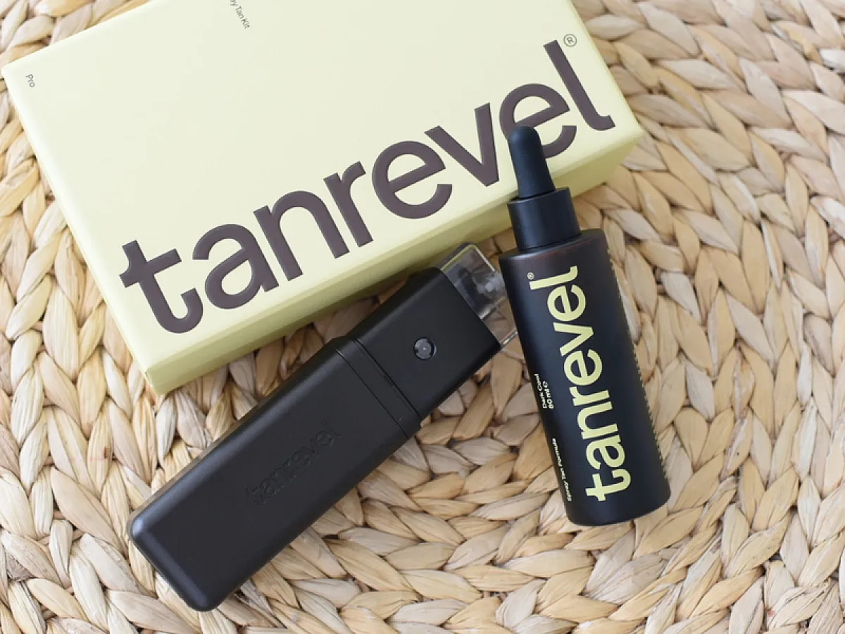Das Tanrevel® Spray Tan Kit Pro, Der Spray Tan Pro liegt auf dem hellgelben Karton