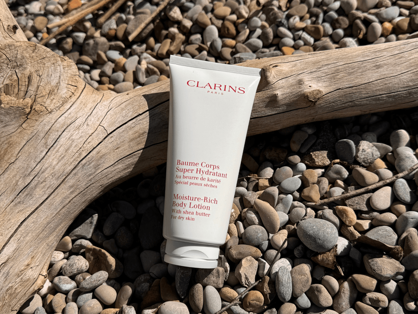 Baume Corps Super Hydratant von Clarins auf Steinen fotografiert
