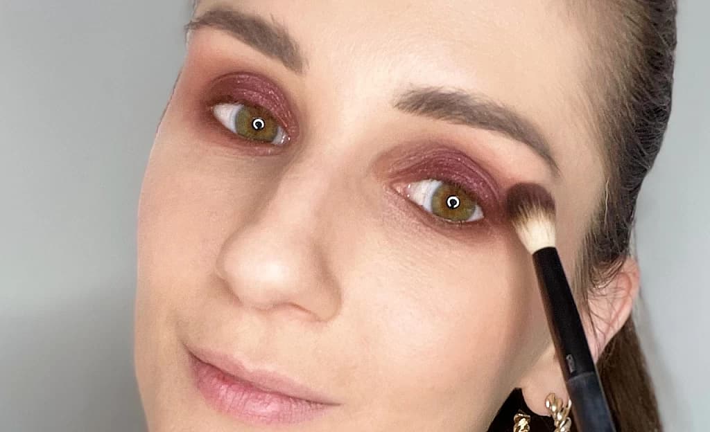 Frau verblendet Smokey Eyes mit Pinsel