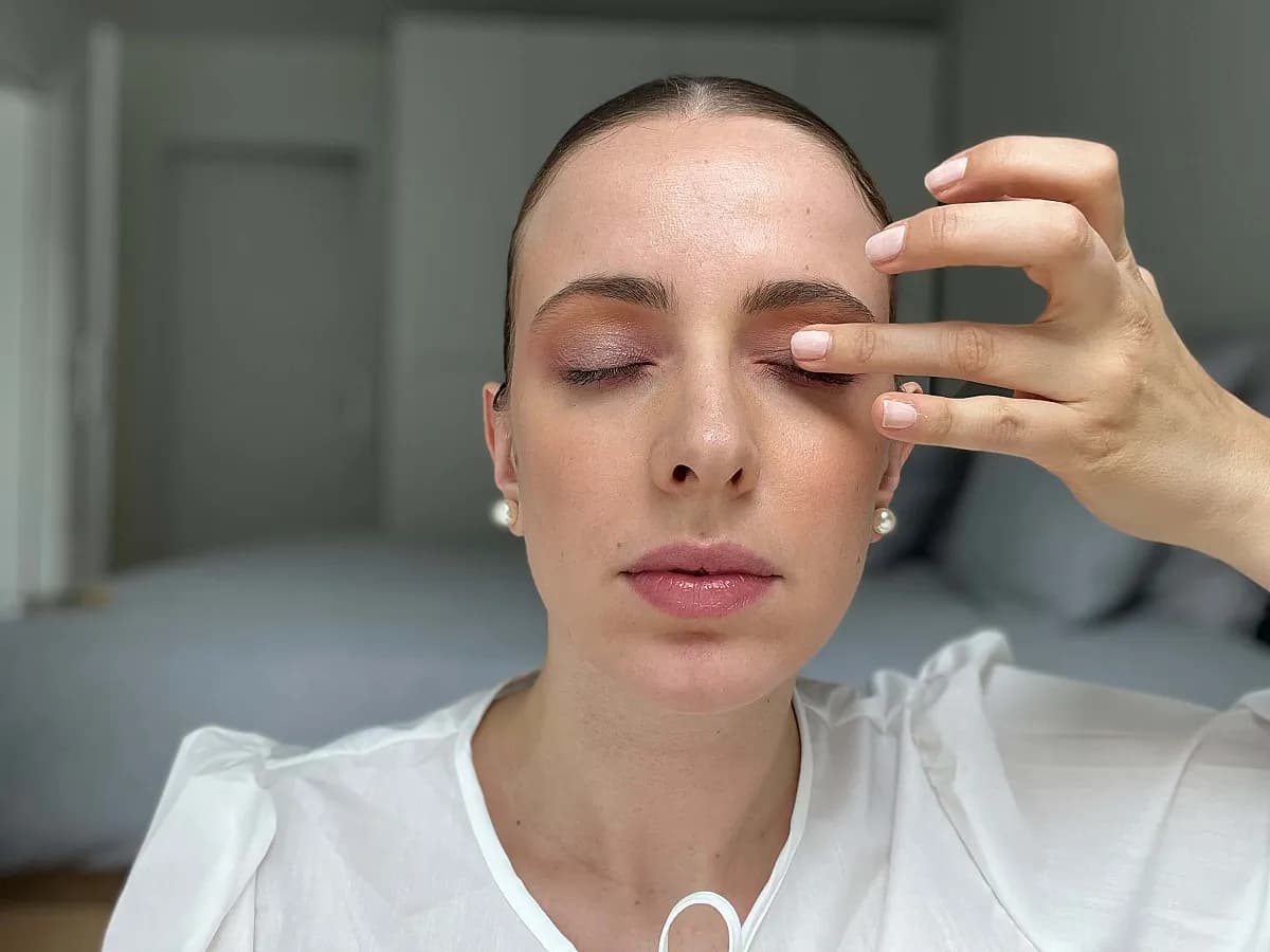 Frau gibt ein wenig funkelnden Lidschatten auf das Augenlid