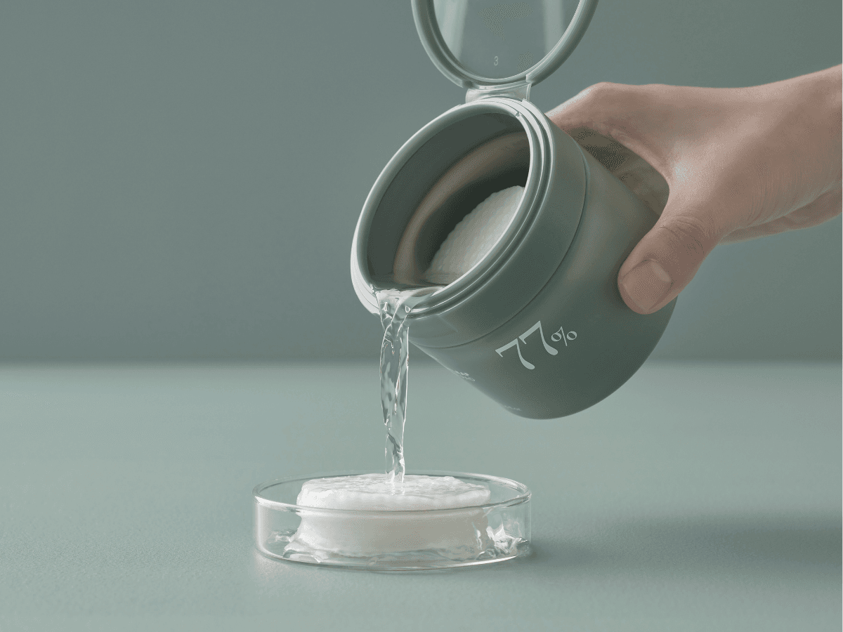 Korean Beauty Brand Anua: Frau giesst Toner auf die Toner Pads von Anua